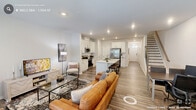 Located in Durham, NC, this well-appointed two-story home offers 3 bedrooms and 3 bathrooms across two thoughtfully designed floors. The main level features an open-concept living and kitchen area bathed in natural light, with light hardwood-style flooring throughout. The kitchen is a standout, boasting a large center island with a built-in sink and white quartz countertops, gray shaker-style cabinetry, stainless steel appliances including a French door refrigerator and range, and recessed lighting. A staircase with a wood railing and modern black balusters connects the two floors seamlessly. The upper level hosts all three bedrooms, including a generously sized primary suite with plush carpeting, a tray ceiling, dual windows for ample natural light, and an en-suite bathroom featuring a glass-enclosed tile shower, a wide vanity with white countertops, and tile flooring. Additional bedrooms offer carpeted or hardwood-style flooring with natural light. A dedicated laundry room with side-by-side washer and dryer adds everyday convenience. The home also includes an attached garage with an electrical panel, completing this functional and modern residence.