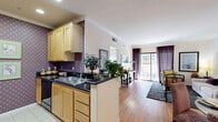 Located at 725 S Bixel St in the heart of downtown Los Angeles, this one-bedroom, one-bathroom residence offers a thoughtfully designed layout across a single floor. The open-plan kitchen and living area serves as the centerpiece of the unit, where light maple cabinetry, dark granite countertops, a decorative patterned backsplash, and tile flooring define the kitchen space. A peninsula counter connects the kitchen seamlessly to the living room, which features warm hardwood flooring, crown molding, and a sliding glass door that opens onto a private balcony with views of the vibrant surrounding streetscape and iconic Los Angeles palm trees. The living room is bright and welcoming, benefiting from generous natural light. The spacious primary bedroom is accented by sage green walls, large windows, hardwood floors, and ample room for a full furniture arrangement. The bathroom is well-proportioned, offering a wood-vanity with a single sink, a full soaking tub with glass enclosure, and tile flooring throughout. A dedicated closet provides practical storage. The overall ambiance is clean, classic, and comfortable — ideal for urban living in one of LA's most accessible downtown neighborhoods.