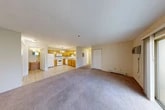 Located at 5772 Stone Gate Heights in Jamesville, NY, this single-floor residence offers a practical and well-organized layout with two bedrooms, two bathrooms, and an abundance of storage across six closets. The open-concept living and kitchen area forms the heart of the home, where warm honey-toned wood cabinetry, white appliances including an electric range, built-in microwave, and dishwasher, and light tile flooring define the kitchen space. The kitchen flows seamlessly into the carpeted living area, which is illuminated by natural light and features sliding glass doors that lead to a private balcony with outdoor views of surrounding greenery. The primary bedroom is generously sized, with a large sliding closet and a window framing views of mature trees. The second bedroom is equally well-appointed with its own window and closet space. Both bedrooms feature plush carpeting and baseboard heating. The two bathrooms include a full bath with a tub-shower combination and tile flooring, as well as a second bath featuring a vanity with wood cabinetry and matching tile. Neutral, light-toned walls throughout the residence create a clean and cohesive aesthetic, making this a move-in ready home in a peaceful Jamesville setting.