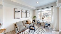 Located in Edmonton's Admiral Girouard neighbourhood, this thoughtfully designed one-bedroom, one-bathroom unit offers a bright and modern living experience across a single floor. The open-concept layout seamlessly connects the kitchen, dining, and living areas, maximizing the sense of space throughout.

The kitchen is a standout feature, equipped with full stainless steel appliances including a French door refrigerator, range, over-the-range microwave, and dishwasher. Crisp white cabinetry, a classic subway tile backsplash, and stone countertops with an undermount sink complete the polished look. A peninsula counter with bar seating adds both functionality and style.

The living area is bathed in natural light from large windows and a glass door that opens onto a private balcony with neighbourhood views. Light-toned luxury vinyl plank flooring runs throughout, tying the space together with a warm, contemporary feel.

The bedroom is a comfortable retreat, featuring a large window with outdoor views, a closet, and direct access to the hallway. The full bathroom includes a soaker tub with shower, complemented by a stone-topped vanity. Additional highlights include a dedicated laundry area and a welcoming entrance with convenient closet storage.