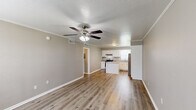This 2-bedroom, 1-bathroom unit in Lafayette, Louisiana offers a thoughtfully designed single-floor layout with modern updates throughout. The open-concept living and kitchen area serves as the heart of the home, featuring warm luxury vinyl plank flooring, neutral gray walls, crown molding, and a textured ceiling with a ceiling fan. The kitchen is well-equipped with white shaker-style cabinetry, granite-look countertops, a central island, stainless steel appliances including a refrigerator, dishwasher, and electric range, plus a window above the sink that brings in natural light.

Both bedrooms continue the cohesive aesthetic with matching flooring, crown molding, ceiling-mounted lighting, and windows with blinds that allow for natural light. The primary bedroom includes a ceiling fan and dual closets, providing generous storage. The second bedroom is comfortably sized and similarly finished.

The bathroom features a full tub-and-shower combination with chrome fixtures. A connecting hallway links the bedrooms and bathroom efficiently. Throughout the unit, clean white trim and baseboards complement the neutral palette, creating a bright and cohesive atmosphere well-suited for comfortable everyday living.