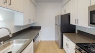 Located at 777 W Covina Blvd in Covina, California, this single-floor residence offers a clean, modern aesthetic with a thoughtfully designed layout. The open living area is finished with light wood flooring and features a ceiling fan, a wall-mounted AC unit, and windows dressed with vertical blinds that allow natural light to fill the space. The bright, neutral color palette throughout creates a welcoming and airy ambiance.

The galley-style kitchen is well-appointed with white shaker cabinetry, dark countertops, stainless steel appliances including a full-size refrigerator, and a built-in dishwasher — offering efficient use of space and a contemporary feel.

The bedrooms are carpeted for comfort and feature neutral walls with textured ceilings. One bedroom includes a mirrored sliding closet with overhead cabinetry, providing generous storage. Windows with vertical blinds allow natural light into the sleeping areas.

The bathroom presents a clean, modern design with white cabinetry, a dark countertop, a vessel-style sink, brushed nickel fixtures, and light wood flooring that carries a cohesive look throughout. Additional built-in cabinetry offers practical storage within the bathroom corridor.

Overall, this residence combines functional design with contemporary finishes, making it a comfortable and well-organized living space in the heart of Covina.