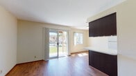 Located at 1515 Broadway in El Cajon, California, this single-floor unit offers a well-organized layout designed for comfortable everyday living. Rich wood-style flooring runs throughout the space, providing a warm and cohesive aesthetic across all rooms.

The living area is bright and open, benefiting from generous natural light that streams in through sliding glass doors leading to a private balcony. The balcony overlooks a landscaped outdoor area, offering pleasant views of greenery and the surrounding community. An adjacent window further enhances the airy feel of the space. A kitchen counter with dark cabinetry extends into the living area, creating a natural division between the living and kitchen spaces.

The kitchen is efficiently designed with dark wood cabinetry — both upper and lower — complemented by a full-size refrigerator, a range, and overhead lighting housed in a recessed ceiling fixture. The layout maximizes usable workspace and storage.

The bedrooms are well-proportioned, each featuring wood-style flooring and windows that invite natural light. At least one bedroom includes a sliding-door closet with built-in shelving. The bathroom is clean and functional, equipped with a full tub and shower combination, a toilet, and a vanity with a dark cabinet base and mirror.