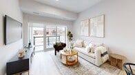 Located at 70 Dean Avenue in Barrie, Ontario, this well-appointed two-bedroom, two-bathroom single-floor residence offers a bright, modern living experience. The open-concept layout seamlessly connects the kitchen and living room, creating a generous and functional shared space. The kitchen is fitted with crisp white cabinetry, a central island with a built-in sink and dishwasher, stainless steel appliances including a full-size refrigerator and range, and pendant lighting — all set atop light-toned hardwood flooring that runs throughout the home. The living room enjoys an abundance of natural light through large sliding glass doors that open to an outdoor balcony, offering views of the surrounding neighbourhood. The spacious primary bedroom features a tray ceiling, wide windows with outdoor views, and a dedicated walk-in closet with wire shelving and hanging storage. The second bedroom is well-proportioned with a large window and the same warm hardwood flooring. Both bathrooms are finished in a clean, neutral palette, each featuring a full soaker tub-shower combination and marble-style tile flooring. A hallway, utility room, and additional closet space complete the thoughtfully designed layout, providing practical storage throughout.