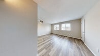 Located at 810 Lasalle Ave in Hampton, Virginia, this single-floor unit offers a clean, updated interior with a cohesive design throughout. Light wood-style flooring extends across the main living areas and bedrooms, creating a bright and airy atmosphere that is complemented by neutral-toned walls and white trim.

The open living area is generously sized, featuring a ceiling fan with a light kit and multiple windows fitted with blinds that allow for natural light and outdoor views of the surrounding neighborhood. The layout flows naturally into the adjacent spaces, making the most of the available footprint.

The kitchen is well-appointed with crisp white shaker-style cabinetry, light quartz-style countertops, and a full suite of stainless steel appliances including a refrigerator, electric range, over-the-range microwave, and dishwasher. A deep stainless steel sink with a modern pull-down faucet completes the functional workspace.

The bedrooms are comfortably proportioned, each with wood-style flooring, neutral walls, and windows that bring in natural light. One bedroom features a ceiling fan, adding to the overall comfort of the space.

The bathroom is neatly finished with a white vanity, tub-shower combination, and wood-style flooring that ties in with the rest of the unit. A hallway with additional doors suggests closet or storage access nearby. Overall, this unit presents a well-maintained, move-in-ready interior.