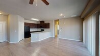 Located at 5300 Outlook Blvd in Pueblo, Colorado, this single-floor unit offers a well-designed, open-concept layout that seamlessly connects the kitchen and living areas. Light-toned wood-style flooring runs throughout, creating a cohesive and clean aesthetic across all rooms.

The kitchen is a standout feature, equipped with rich dark wood cabinetry that extends to the upper walls, providing generous storage. Granite-style countertops add a refined touch, while the full suite of black appliances—including a refrigerator, range, and over-the-range microwave—offers a sleek, uniform look. A curved peninsula serves as a natural divider between the kitchen and the open living space, offering additional counter seating.

The living area is spacious and airy, illuminated by a ceiling fan with light fixture and large sliding glass doors dressed with vertical blinds that allow natural light to filter in. An additional window in the bedroom further enhances the brightness of the unit, with views of the surrounding community.

The bathroom is well-appointed with a granite-topped vanity, dark wood cabinetry, a tiled shower-tub combination with a dark accent tile border, and matching wood-style flooring. Paneled interior doors and neutral wall tones throughout contribute to a clean, contemporary feel.