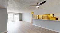 Located on Blix Street in North Hollywood, this 4-bedroom, 2-bathroom single-floor unit offers a practical and well-designed layout. Light wood-style flooring runs throughout, complementing a neutral gray and white color palette that gives the space a clean, modern feel.

The combined kitchen and living area forms the heart of the unit. The kitchen features a peninsula-style breakfast bar, stainless steel appliances including a refrigerator, gas range, and microwave, along with light-toned cabinetry and a stacked in-unit washer and dryer. A ceiling fan overhead and sliding glass door opening to an outdoor balcony bring natural light and airflow into the living area.

The primary bedroom is a generously sized room with a mirrored sliding closet and direct access to the rest of the unit. The additional three bedrooms are well-proportioned and bright, each featuring light flooring, neutral walls, and windows with blinds that allow for natural light. A dedicated closet provides additional storage.

Both bathrooms are finished with white vanity cabinetry, light countertops, and a tub-shower combination with brushed nickel fixtures. The textured ceilings are consistent throughout the unit, adding a classic residential character to the overall space.