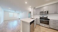 Located at 3000 Van Buren Blvd in Riverside, CA, this well-appointed 1-bedroom, 1-bathroom residence offers a thoughtfully designed single-floor layout with modern finishes throughout. The open-concept kitchen and living area serves as the heart of the home, featuring light wood-style flooring, recessed lighting, and a ceiling fan that enhances the bright, airy atmosphere. The kitchen is outfitted with gray shaker-style cabinetry, a classic white subway tile backsplash, a peninsula island with a white quartz countertop and undermount sink, and a full suite of stainless steel appliances including a gas range, over-the-range microwave, dishwasher, and refrigerator. Natural light flows into the living area through multiple windows. The bedroom offers plush carpeting, a ceiling fan, and windows with blinds that allow adjustable natural light. The bathroom is clean and contemporary, showcasing gray cabinetry, a white quartz vanity countertop, a tub-shower combination with tile surround, and wood-style flooring. A dedicated closet and hallway round out the functional layout, making efficient use of the available space throughout this move-in-ready residence.