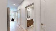 Located at 850 Jaeger St. in Columbus, Ohio's vibrant German Village area, this thoughtfully designed studio offers a modern, efficient layout across a single floor. The open living area is bright and welcoming, featuring light hardwood flooring, crisp white walls, and large windows with horizontal blinds that allow generous natural light and outward views of the surrounding neighborhood. The sleeping area is seamlessly integrated, complete with a built-in shelving unit for added storage and organization. A stylish sliding barn door connects the main living space to the hallway, adding a contemporary architectural touch. The kitchen is well-appointed with white shaker-style cabinetry, quartz countertops, stainless steel appliances including a range and built-in microwave, a deep undermount sink, and a striking white penny-tile backsplash. The bathroom features warm wood-toned cabinetry, a white quartz vanity top, a large rectangular mirror with modern lighting, and elegant stone tile flooring. A dedicated laundry area includes a stacked Samsung washer and dryer alongside a walk-in closet with wire shelving. Clean lines and neutral tones throughout create a cohesive, modern aesthetic ideal for comfortable urban living.