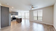 Located at 15915 Kingfield Dr in Houston, TX, this well-appointed single-story home offers three bedrooms and three bathrooms across a thoughtfully designed floor plan. The open-concept living and kitchen area serves as the heart of the home, featuring light hardwood-style flooring, a ceiling fan, and recessed lighting. The kitchen is outfitted with dark wood cabinetry, granite countertops, a white subway tile backsplash, stainless steel appliances including a refrigerator, electric range, and microwave, as well as a central island with a built-in wine rack and pendant lighting above. Large windows in the living area flood the space with natural light and offer outdoor views. The bedrooms are bright and comfortable, each with hardwood-style flooring and ceiling fans. The primary bedroom is generously sized, while additional bedrooms feature large windows with outdoor views and ample closet space. The bathrooms are finished with dark wood vanities, granite countertops, tile surround tub-shower combinations, and brushed nickel fixtures. A hallway connects the rooms efficiently, and two closets provide additional storage throughout the home.