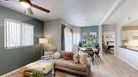 Located in Phoenix, AZ, this 2-bedroom, 2-bathroom residence offers a thoughtfully designed single-floor layout that maximizes functionality and style. The open-concept living and dining area serves as the heart of the home, featuring light wood-style flooring, ceiling fans, and striking teal accent walls that add a bold, modern character throughout. Large windows and sliding glass doors allow natural light to fill the space, creating a bright and welcoming atmosphere.

The kitchen is outfitted with white cabinetry, dark countertops, a tile backsplash, stainless steel appliances, and track lighting — offering both style and practicality. A breakfast bar provides additional prep and dining space. The adjacent dining area comfortably accommodates a round table and is highlighted by a teal feature wall adorned with framed artwork.

Both bedrooms are well-proportioned, each equipped with a ceiling fan and ample closet space. The primary bedroom offers a serene retreat with neutral tones and natural light. The two bathrooms feature wood-look tile flooring, dark countertops, white cabinetry, and a tub-shower combination. Two dedicated closets provide generous storage throughout the residence. The overall ambiance is modern, cohesive, and move-in ready.