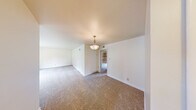 This single-story, 2-bedroom, 1-bathroom home offers a practical and comfortable layout designed to maximize everyday living. The living room is generously sized, featuring neutral-toned carpet, crisp white walls, and a large window that fills the space with natural light and offers views of the surrounding greenery. A decorative pendant light fixture adds a warm, inviting touch to the area.

The kitchen is well-equipped with rich dark wood cabinetry, granite-look countertops, a tile backsplash, and white appliances including a range and microwave. Light ceramic tile flooring and a window above the sink contribute to a bright and functional cooking space.

The primary bedroom offers comfortable proportions and includes a mirrored sliding closet with built-in shelving for organized storage. The second bedroom is carpeted and features a window with outdoor views, a ceiling light, and easy access to the hallway. A dedicated closet provides additional storage options.

The bathroom is tastefully finished with tile flooring, a tiled tub and shower combination with a handheld showerhead, a dark wood vanity, and a window that brings in natural light. A hallway connects the rooms efficiently, completing this well-organized and move-in ready home.