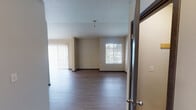 Located at 11425 Tenth Avenue Ct E in Tacoma, Washington, this single-floor residence offers a thoughtfully organized layout with a neutral color palette and modern finishes throughout. The open living area greets residents upon entry, showcasing durable wood-style plank flooring, warm beige walls, and dark baseboards that provide clean visual contrast. Large windows and a sliding glass door fitted with vertical blinds flood the space with natural light while offering views of the surrounding exterior.

The kitchen features an efficient U-shaped configuration with ample white cabinetry, stone-patterned countertops, a stainless steel sink, and a window above that brings in additional natural light. Appliances including a range and dishwasher are integrated into the design.

The bedrooms are carpeted for added comfort, each receiving natural light through windows with blinds and equipped with baseboard heating. Closet access is available within the bedroom corridor.

Two full bathrooms serve the unit, each outfitted with white vanity cabinetry, stone-finish countertops, a tub-shower combination with marble-style tile surround, and wood-style flooring. The 3D floor plan confirms a well-segmented layout that balances private and shared living spaces efficiently.