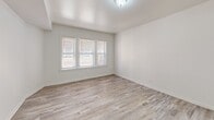 This 670 square foot apartment in Chicago offers a thoughtfully designed living space with two bedrooms and one bathroom. The single-floor layout maximizes functionality within its compact footprint. Upon entering, you're greeted by a cohesive design aesthetic featuring wood-look flooring that flows seamlessly throughout the apartment, creating a sense of continuity and warmth.

The living room serves as the heart of the home, boasting multiple windows that flood the space with natural light. The primary bedroom, measuring 130 square feet, provides a comfortable retreat with ample room for a bed and essential furnishings. Both bedrooms feature crisp white walls and wood-look flooring, creating a clean and inviting atmosphere.

The kitchen showcases a modern design with light blue cabinetry, contrasting beautifully against white countertops. Under-cabinet lighting adds a warm glow, while stainless steel appliances, including a gas range, offer both style and functionality. The bathroom, though compact, is efficiently designed with a single vanity, medicine cabinet, and modern fixtures.

Throughout the apartment, white walls and trim work create a bright, airy feel, amplifying the natural light from the numerous windows. The overall design aesthetic is clean and contemporary, appealing to those who appreciate minimalist, low-maintenance living spaces.