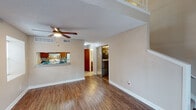 Located at 5757 Wooldridge Rd in Corpus Christi, Texas, this two-story residence offers a well-organized layout across two distinct levels. The main floor features durable wood-look flooring throughout the living and dining areas, which are bathed in natural light from a large sliding glass door fitted with vertical blinds that leads to an outdoor area. A ceiling fan with integrated lighting adds comfort to the spacious living room, which also benefits from an additional side window.

The kitchen is appointed with warm wood cabinetry, granite-style countertops, a white electric range, and a colorful mosaic tile backsplash. A pass-through window connects the kitchen to the living area, promoting an open, sociable flow. A bathroom on the main level includes a vanity with granite-style countertops, rich wood cabinetry, and a full tub-shower combination.

Upstairs, an open loft area overlooks the lower level via a white spindle railing, offering versatile use as a secondary living space or home office. The upper level is carpeted for comfort and features a ceiling fan and natural window light. A private bedroom also resides upstairs, complete with plush carpet, a charming window seat, and a textured ceiling. Throughout, textured ceilings and neutral warm-toned walls create a cohesive and inviting atmosphere.