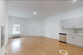 Located at 115 Main Street in Lincoln Park, NJ, this thoughtfully designed one-bedroom, one-bathroom residence offers a clean, modern aesthetic throughout. The open-concept kitchen and living area serves as the heart of the unit, featuring warm hardwood-style flooring, crisp white walls, and abundant natural light from large windows. The kitchen is well-appointed with sleek gray cabinetry extending to the ceiling, quartz countertops, a textured tile backsplash, and a full suite of stainless steel appliances including a dishwasher, range, microwave, and refrigerator. The living area offers a generous, flexible layout with a panel box conveniently recessed into the wall. The bedroom is a comfortable, quiet retreat with its own window, a wall-mounted HVAC unit, and access to a dedicated walk-in closet fitted with wire shelving. The bathroom presents a clean, all-white design with large-format tile flooring and accessibility-friendly grab bars. Additional highlights include an in-unit laundry area and a utility room. The consistent hardwood-style flooring and neutral color palette create a cohesive, move-in-ready living environment throughout the entire space.