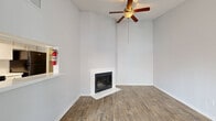 Located at 10730 Glenora Dr in Houston, TX, this single-floor, 2-bedroom, 2-bathroom home offers a well-organized layout designed for comfortable everyday living. The living room serves as the heart of the home, featuring soaring ceilings, a classic wood-burning fireplace with a white surround, durable wood-look flooring, and a ceiling fan with light fixture. Natural light filters in through a sliding glass door, while a pass-through opening connects the space to the kitchen. The galley-style kitchen is efficiently designed with white cabinetry, light countertops, black appliances, a stainless steel sink with a flexible faucet, track lighting, and direct access to a dedicated pantry. Both bedrooms are carpeted for comfort and include ceiling fans and windows that bring in natural light. Each bedroom features its own closet, offering ample storage. The two bathrooms mirror each other in clean, neutral finishes, with wood-look flooring, white vanities with light countertops, large mirrors, and tub-shower combinations. The primary bedroom is generously proportioned, providing a comfortable private retreat. The overall aesthetic throughout is bright and neutral, with light gray walls and white trim creating a clean, move-in-ready atmosphere.