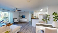 Located at 4132 53rd Ave W in Bradenton, Florida, this single-story residence offers a well-designed, open-concept layout filled with natural light and contemporary finishes throughout. The living area is anchored by wood-look flooring, a ceiling fan, and a sliding glass door that frames outdoor views and floods the space with Florida sunshine. A floating media console and neutral wall tones contribute to the clean, modern aesthetic.

The kitchen is thoughtfully arranged with white shaker cabinetry, dark countertops, stainless steel appliances including a refrigerator, dishwasher, and range, and a pass-through counter that opens toward the dining area. A dedicated pantry closet provides additional storage. An entry hallway features a reach-in closet for added convenience.

The bedrooms are carpeted for comfort, each equipped with ceiling fans and walk-in closets with wire shelving systems. Natural light enters through windows with views of surrounding greenery. The bathroom offers a single-sink vanity with dark countertops, white cabinetry, and a tub-shower combination. A dedicated laundry area houses a full-sized washer and dryer with overhead shelving, rounding out the functional and comfortable design of this Bradenton residence.