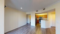 This single-floor residence offers a thoughtfully designed layout that combines comfort and functionality. The open-concept living area flows seamlessly into the kitchen, which features warm honey-toned cabinetry, granite-style countertops, a double stainless steel sink, and a full suite of stainless steel appliances including an electric range, microwave, and refrigerator. A breakfast bar provides a convenient transition between the kitchen and living space. Crown molding and recessed lighting add a refined touch to the main living area, which opens onto a private balcony through sliding glass doors, bringing in natural light and outdoor views.

The bedrooms are generously sized, each equipped with a ceiling fan and hardwood-style flooring. One bedroom features a walk-in closet and a large window overlooking mature trees, while the other includes direct access to a dedicated walk-in closet. Both bathrooms are appointed with rich cherry-toned vanities, granite-style countertops, large mirrors, and tiled shower-tub combinations. Consistent hardwood-style flooring runs throughout the entire residence, creating a cohesive and polished aesthetic. The overall ambiance is bright, clean, and move-in ready.