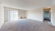 Located at 150 E Schiller St in Elmhurst, Illinois, this single-floor residential unit offers a well-organized and functional layout spread across multiple rooms. The spacious living area is finished with plush carpeting and features a sliding glass door that opens to a balcony, allowing natural light to fill the space and providing views of the surrounding neighborhood. A second carpeted room also benefits from a sliding glass door and an additional window, further enhancing the brightness throughout.

The galley-style kitchen is efficiently designed with white cabinetry, ample counter space, a built-in sink, and white appliances including a range, all set atop classic tile flooring. Two full bathrooms are present, each outfitted with a tub-shower combination, toilet, and vanity mirror, finished in clean, neutral tones with tile flooring.

The bedrooms feature soft carpeting and generous closet space, with bi-fold closet doors providing easy access to storage. A dedicated laundry area houses a stacked washer and dryer unit, adding everyday convenience. Throughout the unit, neutral wall colors and consistent flooring choices create a cohesive, move-in-ready environment suited for comfortable residential living.