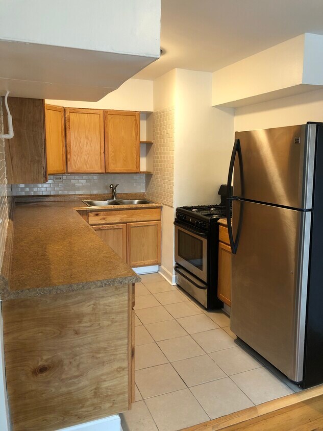 Kitchen - Includes stainless steel refrigerator and gas stove. White subway tile backsplash. - 5335 N California Ave