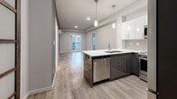 Located at 711 Treanor Avenue in Langford, BC, this thoughtfully designed 2-bedroom, 1-bathroom unit offers a modern aesthetic throughout its efficiently planned single-floor layout. The open-concept living area seamlessly integrates the kitchen, dining, and living spaces, all finished with light wood-look flooring that enhances the bright, airy atmosphere. The contemporary kitchen is a standout feature, showcasing two-tone cabinetry with dark lower and white upper cabinets, a crisp white quartz peninsula with bar seating, stainless steel appliances including a dishwasher, and stylish pendant lighting overhead. A tiled backsplash and ample upper cabinet storage add both function and style. The living area extends toward a balcony, inviting natural light deep into the space. The two bedrooms are carpeted for comfort, each featuring distinctive sliding closet doors with dark wood frames and frosted glass panels — a striking design detail. The full bathroom is finished in a clean, minimalist style with neutral tile flooring, a white vanity, and a full soaker tub with shower. A dedicated in-unit laundry area with wire shelving adds everyday convenience. Two closets provide additional storage throughout the unit.
