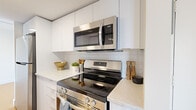 Located at 2060 Quingate Place in Halifax, Nova Scotia, this single-floor unit offers three bedrooms, one bathroom, and a thoughtfully arranged layout that makes efficient use of its space. Light wood laminate flooring runs throughout, creating a warm and cohesive feel across all rooms.

The kitchen is a standout feature, showcasing white flat-front cabinetry extending to the ceiling, stone-look countertops, a white subway tile backsplash, and a full suite of stainless steel appliances including a glass-top range, over-the-range microwave, refrigerator, and dishwasher. The galley-style layout maximizes functionality while maintaining a clean, modern aesthetic.

The generously sized primary bedroom benefits from a large window that frames outdoor views and fills the room with natural light. The remaining bedrooms are well-proportioned and each features sliding-door closets with built-in hanging rods, providing ample storage.

The bathroom is finished in a crisp all-white palette, complete with a vanity cabinet, mirror, and a tub-shower combination. A dedicated laundry area houses a stacked Samsung washer and dryer, adding in-unit convenience. A central hallway connects all rooms, contributing to an organized and practical floor plan throughout.