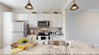 Located at 484 Greenmont Dr in Lewis Center, Ohio, this two-story home offers a well-designed layout with thoughtful finishes throughout. The kitchen is a standout feature, showcasing granite countertops, white shaker-style cabinetry, stainless steel appliances including a refrigerator, range, and built-in microwave, and a peninsula with an undermount sink. Stylish pendant lighting adds a modern touch overhead. The bedrooms are generously sized with vaulted ceilings, plush carpeting, and windows that allow natural light to filter in. Each bedroom benefits from walk-in closet space equipped with wire shelving systems, providing ample storage. The bathroom is neatly appointed with granite vanity countertops, white cabinetry, wood-look flooring, and a full tub-shower combo. A dedicated laundry room houses a full-size washer and dryer alongside utility shelving, adding everyday convenience. Throughout the home, neutral tones, clean lines, and consistent finishes create a cohesive and inviting atmosphere. The two-floor layout offers a practical separation of living and private spaces, making this home in the Lewis Center community a functional and comfortable residence.