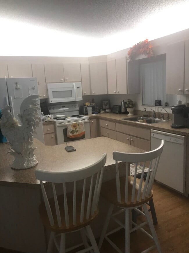 open kitchen looks out to large tiled, enclosed lanai - 9735 SE 176th St