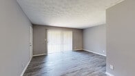 Located at 1231 Clairmont Rd in Decatur, GA, this single-story 2-bedroom, 1-bathroom home offers a functional and comfortable layout with consistent neutral-toned finishes throughout. The living room is anchored by durable hardwood-style flooring and features large sliding glass doors fitted with vertical blinds, allowing ample natural light to fill the space. A second windowed room with matching flooring provides additional flexible living or dining space. The kitchen is well-appointed with gray shaker-style cabinetry, marble-look countertops and backsplash, a double stainless steel sink, and a stainless steel dishwasher, all illuminated by a bright window. Both bedrooms are finished with plush carpeting and ceiling fans with light fixtures, creating a comfortable and quiet retreat. The spacious primary bedroom features two closets, offering generous storage. The secondary bedroom also benefits from natural light via a large window. The full bathroom includes a tiled tub-shower combination with sliding glass doors, white tile walls, and hardwood-style flooring. A hallway connects the main living areas to the bedrooms, and a walk-in closet provides additional storage. The home's cohesive gray color palette and clean finishes lend a modern, move-in-ready appeal.