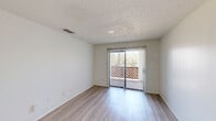 Located at 16465 Henderson Pass in San Antonio, Texas, this single-floor, three-bedroom, two-bathroom home offers a functional and comfortable layout with clean, neutral finishes throughout. The combined kitchen and living area serves as the heart of the home, featuring light wood-style flooring, white cabinetry, a peninsula with a built-in sink, and stainless steel appliances including a refrigerator, range, and microwave. The living room is bright and open, with a sliding glass door fitted with vertical blinds that leads to an outdoor deck, allowing natural light to fill the space. The bedrooms provide a mix of flooring options — light wood-style in some rooms and plush carpet in others. The primary bedroom includes a ceiling fan with integrated lighting and access to a dedicated closet. The additional bedrooms offer clean white walls and ample space. Both bathrooms are finished with light wood-style flooring and include tub-shower combinations with white tile surrounds and chrome fixtures. Throughout the home, textured ceilings, white walls, and neutral tones create a cohesive and move-in-ready atmosphere well-suited for comfortable everyday living.