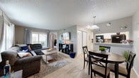 Located at 12001 Belcher Rd S in Pinellas Park, Florida, this well-appointed one-bedroom, one-bathroom residence offers a smart, functional layout across a single floor. The open-concept main living area seamlessly integrates the living room, dining room, and kitchen, creating an efficient and connected space. Light tile flooring runs throughout, complemented by neutral-toned walls and textured ceilings that add subtle depth.

The living room is bright and inviting, with a large window that allows natural light to fill the space. It flows directly into the dining area, which is anchored by a pendant light overhead. The kitchen is well-equipped, featuring white shaker-style cabinetry, granite countertops, a mosaic tile backsplash, and black appliances including a range, microwave, and refrigerator.

The bedroom is generously sized and features sliding glass doors that provide direct access to an outdoor area and fill the room with natural light. The full bathroom includes a white vanity with granite countertops, a tub-shower combination, and tile flooring. Additional practicalities include a dedicated closet and an in-unit laundry area, rounding out this well-organized and comfortable Pinellas Park residence.