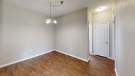 Located at 7101 Wilson Blvd in Jacksonville, FL, this single-floor, 2-bedroom, 2-bathroom residence offers a practical and well-organized layout. The kitchen is a standout feature, equipped with black appliances including a refrigerator, range, and over-the-range microwave, complemented by light wood cabinetry, laminate countertops, and a double-basin sink. A wraparound peninsula counter provides additional workspace and separates the kitchen from the adjacent dining area, which features rich wood-style flooring and an overhead chandelier that adds a touch of warmth. A dedicated closet near the kitchen entry provides convenient storage. Both bedrooms are carpeted for comfort and finished in neutral tones, with windows that allow natural light and views of surrounding greenery. The primary bedroom offers a generous footprint with ample room for furnishings. The two bathrooms are functionally appointed, each featuring wood-style flooring, light cabinetry with laminate counters, and a full tub/shower combination. Neutral wall tones and clean white trim are consistent throughout, giving the space a cohesive and move-in-ready appearance. The overall layout is efficient, making effective use of the available square footage.