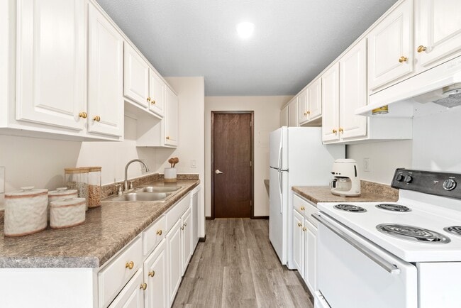 Welcome to Como Park Apartments, where modern living meets comfort. This spacious kitchen features elegant cabinetry and updated appliances, perfect for culinary enthusiasts. Come see how you can elevate your lifestyle today! Schedule a tour now! - Como Park Apartments