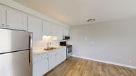 Located on Fort Campbell Blvd in Clarksville, Tennessee, this efficient one-bedroom, one-bathroom unit offers a thoughtfully designed single-floor layout. The kitchen is a standout feature, showcasing crisp white cabinetry with ample storage, a classic subway tile backsplash, light marble-look countertops, and a full suite of stainless steel appliances including a refrigerator, electric range, and over-the-range microwave. Warm wood-look flooring runs throughout the kitchen and living areas, lending a clean and cohesive aesthetic. The bedroom is a comfortable retreat finished with plush wall-to-wall carpeting, neutral gray walls, a ceiling fan with light fixture, and a window with blinds that invites natural light. Direct access to both a dedicated closet and the bathroom adds everyday convenience. The bathroom is neatly appointed with wood-look tile flooring, a pedestal sink, an oval mirror with modern vanity lighting, and a full tub/shower combination. The overall ambiance of the unit is bright, clean, and move-in ready, making it a practical and comfortable living space.