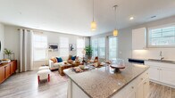 This well-appointed single-floor residence offers a thoughtfully designed open-concept layout that seamlessly connects the kitchen, dining, and living areas. The kitchen is a standout feature, showcasing white shaker cabinetry, granite countertops, a classic subway tile backsplash, stainless steel appliances, and a large island with pendant lighting and bar seating — ideal for both cooking and casual dining. Wood-look luxury vinyl plank flooring runs throughout the main living spaces, adding warmth and durability.

The living room is generously sized and bathed in natural light from multiple windows fitted with blinds and decorative curtains. Recessed lighting complements the bright, neutral palette, creating an inviting and airy atmosphere throughout.

The bedroom is a comfortable retreat, featuring plush carpet, a ceiling fan, and ample natural light. It connects directly to a well-proportioned en-suite bathroom with granite countertops, white cabinetry, wood-look flooring, and access to a spacious walk-in closet with multi-tier wire shelving. A central hallway links all areas of the home efficiently, with additional storage and easy access to all rooms. The overall design is clean, modern, and move-in ready.