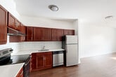 Located at 747 Grand Street in Jersey City, NJ, this well-appointed residence offers two bedrooms and two bathrooms across a single floor. The layout is designed for comfortable everyday living, with hardwood-style flooring flowing throughout the space and clean white walls that lend a bright, neutral backdrop to every room.

The kitchen is a functional highlight, featuring rich dark cherry cabinetry, white subway tile backsplash, light countertops, and a full suite of stainless steel appliances including a refrigerator, dishwasher, and range. The kitchen opens toward the living area, which benefits from natural light streaming through a window with neighborhood views.

The generously sized primary bedroom offers ample space and connects to its own bathroom, while the second bedroom includes a closet with a hanging rod for convenient storage. Both bedrooms feature the same hardwood-style flooring and neutral tones, creating a calm, cohesive atmosphere.

The two bathrooms are finished with subway tile wainscoting, warm wood vanities with white countertops, and chrome fixtures. One bathroom includes a tiled walk-in shower with mosaic floor detailing. A connecting hallway ties the layout together efficiently, making this residence a practical and attractive option in Jersey City.