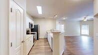 Located at Villa Capri Circle in Odessa, Florida, this 2-bedroom, 3-bathroom residence offers a well-designed single-floor layout with a bright, open feel throughout. The heart of the home is an open-concept kitchen and living area, where warm wood-style flooring flows seamlessly underfoot. The kitchen features white cabinetry, light countertops, stainless steel appliances including a refrigerator, range, microwave, and dishwasher, and a peninsula with a double sink that overlooks the living space. The spacious living room is bathed in natural light from multiple windows and a glass-panel door, and is accented by a ceiling fan overhead. French-style doors add an elegant touch to the living area's entry points. Both bedrooms are carpeted for comfort and include ceiling fans and windows with blinds. The primary bedroom features direct access to an en-suite bathroom and generous closet space. The bathrooms are clean and functional, with white vanities, framed mirrors, and tub-shower combinations. A dedicated laundry area and an abundance of closets — eight in total — provide exceptional storage. The overall palette of neutral beige tones and white trim creates a cohesive, move-in-ready aesthetic throughout the home.