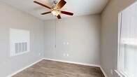 Located at 1925 Clearfork St in Lockhart, Texas, this single-story, one-bedroom, one-bathroom home offers a well-designed layout that maximizes every square foot of its comfortable living space. Warm-toned, wood-look plank flooring runs throughout the main areas, complemented by neutral gray walls and clean white trim that give the home a fresh, modern feel. The open-concept kitchen and living room serve as the heart of the home, where a spacious white quartz peninsula with pendant lighting creates a natural gathering point. The kitchen is equipped with rich dark cabinetry, a white appliance suite, and a window that brings in natural light. A ceiling fan in the living area adds both comfort and style. The generously sized bedroom features its own ceiling fan, a window for natural light, and direct access to a walk-in closet outfitted with wire shelving for organized storage. The bathroom offers a dark-vanity with a white countertop, a large mirror, and tile flooring, providing a clean and functional space. A dedicated laundry area houses a front-load washer and includes additional shelving for convenience. A separate utility room rounds out the home's practical amenities, making this property a well-appointed and efficiently organized living space.