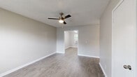 Located at 550 Crossway Ave in Murfreesboro, TN, this two-bedroom, one-bathroom unit offers a practical and well-organized single-floor layout. The living room welcomes you with durable wood-look flooring, neutral warm-toned walls, a ceiling fan with light fixture, and a window fitted with blinds that allows natural light to filter through.

The kitchen features a distinctive farmhouse-inspired aesthetic with dark, barn-style cabinet doors — both upper and lower — contrasted against white countertops and a double stainless steel sink. White appliances, including an electric range and refrigerator, complete the functional setup. An adjacent dining or utility area with a window and wall-unit air conditioner provides additional flexibility.

Both bedrooms are carpeted and outfitted with ceiling fans, offering a comfortable and quiet retreat. Each room includes windows with blinds for natural light and ventilation. Closet access is present in the primary bedroom.

The bathroom is clean and functional, featuring wood-look flooring, a full tub/shower combination with safety grab bars, and a vanity with dark cabinetry consistent with the kitchen's style.

Throughout the unit, textured ceilings, clean white trim, and a cohesive neutral color palette create a simple and tidy living environment.