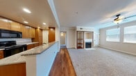 This single-floor, 3-bedroom, 2-bathroom residence offers a comfortable and functional layout with a well-considered mix of materials and finishes. The open-concept kitchen and living area serves as the heart of the home, where warm wood-toned cabinetry, granite countertops, and hardwood flooring define the kitchen space. Stainless steel appliances, recessed lighting, and ample cabinet storage make the galley-style kitchen both practical and attractive. The living room transitions seamlessly from hardwood to plush carpet and is anchored by a charming fireplace framed with built-in shelving and distinctive wood trim detailing — an ideal spot for relaxing or entertaining. Crown molding throughout adds a refined touch to the overall aesthetic. The spacious primary bedroom features multiple windows that invite natural light, soft carpeting, and a ceiling fan for year-round comfort. Additional bedrooms are well-sized with neutral tones and carpeted floors. The bathrooms are cleanly finished, with one featuring a tub-shower combo enclosed by sleek sliding glass doors with matte black hardware. A private balcony extends the living space outdoors, offering pleasant views of lush, mature trees and the surrounding neighborhood under open skies.