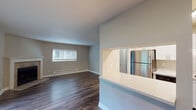 Located at 4200 SW 107th Ave in Beaverton, Oregon, this single-floor unit offers a well-designed layout with a comfortable flow throughout. The open living area features rich dark hardwood-style flooring, a ceiling fan, and generous natural light from multiple windows with views of surrounding greenery. A tile-surround fireplace with a classic white mantel serves as a focal point in the main living space, adding warmth and character.

The kitchen is efficiently designed with crisp white cabinetry, stainless steel appliances including a refrigerator and range, and a pass-through window that connects to the adjacent living and dining area, enhancing the open feel. Light wood-style flooring in the kitchen complements the clean, modern aesthetic.

The bedroom offers plush carpeting, a bright window, and baseboard heating, creating a comfortable and quiet retreat. Two bathrooms serve the unit — one full bath featuring a glass-enclosed shower, a wide vanity with ample counter space, and a large mirror, and a second bath with a single-sink vanity and hardwood-style flooring. Baseboard heating is present throughout, ensuring year-round comfort. Overall, the unit presents a clean, updated interior well-suited for functional everyday living.