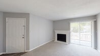 Located at 834 Lakecrest Ave in High Point, NC, this single-story unit offers a practical and comfortable layout designed for everyday living. The living room serves as the central gathering space, featuring soft carpeting, neutral gray walls, a white-mantled wood-burning fireplace, and a sliding glass door that floods the room with natural light while providing direct access to an outdoor area. A pass-through opening connects the living room to the kitchen, promoting an open, connected feel between the two spaces.

The galley-style kitchen is efficiently organized with white cabinetry, light-toned countertops, a stainless steel sink, and black appliances including a refrigerator, electric range, microwave, and dishwasher. Wood-look flooring adds a clean, durable finish underfoot.

The bedrooms are carpeted and painted in soft gray tones, each equipped with ceiling fans and window blinds that allow for natural light and ventilation. One bedroom offers dual windows, while another features a closet and a single window overlooking greenery outside.

The bathroom includes a tub-shower combination with a molded surround and brass hardware accents. Throughout the unit, consistent neutral tones and clean finishes create a cohesive, move-in-ready atmosphere.