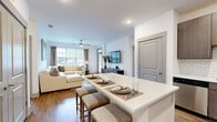 Located in Indian Trail, NC, this thoughtfully designed 2-bedroom, 2-bathroom residence offers a modern aesthetic with quality finishes throughout. The open-concept kitchen is a standout feature, showcasing rich dark wood cabinetry, white quartz countertops, a classic subway tile backsplash, warm hardwood-style flooring, and a full suite of stainless steel appliances. A generous island provides additional prep and dining space, flowing seamlessly into the living area. The living room is bright and welcoming, with large windows fitted with blinds that invite natural light and offer outdoor views, complemented by a ceiling fan overhead and hardwood-style flooring underfoot. Both bedrooms are carpeted and well-sized, each featuring windows with outdoor views and ceiling fans. The primary bedroom includes a spacious walk-in closet with wire shelving systems offering ample storage. The two bathrooms are finished with dark wood vanities, white countertops, and hardwood-style flooring. One bathroom features a full tub-shower combination with tile surround, while the second offers a clean, minimalist vanity setup. Together, the rooms create a cohesive, modern living environment designed for comfort and functionality.