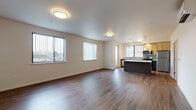 Located at 970 W 17th Ave in Junction City, Oregon, this contemporary two-floor residence offers a thoughtfully designed layout with modern finishes throughout. The open-concept main living area features rich hardwood-style flooring, neutral walls, and multiple windows dressed with vertical blinds that invite generous natural light. A wall-mounted mini-split unit provides efficient climate control.

The kitchen is a standout feature, centered around a large island with a sleek white countertop and dark cabinetry. It is outfitted with stainless steel appliances, including a refrigerator, range, and over-the-range microwave, complemented by warm wood-toned upper cabinets and a teal glass tile backsplash. Pendant lighting and ample counter space make this an ideal space for both cooking and entertaining.

The bedrooms are carpeted for comfort, each with windows that allow for natural light and outdoor views. The bathrooms maintain a clean, modern aesthetic with dark-toned vanity cabinetry, white countertops, and light wood-style flooring. One bathroom includes a soaking tub and shower combination with grab bars, while another features a sleek, minimalist design. The overall ambiance throughout is fresh, clean, and move-in ready.