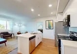 Located at 2829 Breaker Way in Stockton, CA, this 1-bedroom, 1-bathroom residence offers a thoughtfully designed single-floor layout with a clean, contemporary aesthetic. The open-concept kitchen and living area serves as the heart of the home, featuring light hardwood-style flooring, recessed lighting, and a central kitchen island with a built-in sink and stainless steel dishwasher. The kitchen is equipped with white cabinetry, a stainless steel refrigerator, an electric range, and an over-the-range microwave, providing ample functionality. The living area offers direct access to an outdoor space through glass patio doors that invite natural light and neighborhood views. The bedroom is a comfortable retreat with plush carpeting, multiple windows with roller shades, a sliding closet, and recessed lighting. The full bathroom features a white vanity with storage, a tub-shower combination with tile surround, and light hardwood-style flooring, maintaining the home's clean and bright palette throughout. Crisp white walls and consistent modern finishes create a cohesive, light-filled ambiance across every room, making this residence a practical and inviting space in Stockton's northwest corridor.