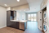 Located at 201 North La Brea Avenue in Inglewood, CA, this modern 2-bedroom, 1-bathroom unit offers a thoughtfully designed open floor plan with contemporary finishes throughout. Wood-style plank flooring flows seamlessly across the entire space, complementing the clean, neutral color palette.

The well-appointed kitchen is a standout feature, offering dark espresso cabinetry extending to the ceiling, stainless steel appliances including a range, microwave, and dishwasher, and white quartz countertops. The kitchen opens directly to the living area, creating an inviting, connected layout ideal for everyday living.

The spacious primary bedroom features sliding glass doors that open to a private balcony, offering sweeping views of the Inglewood skyline and beyond. The second bedroom also benefits from generous natural light through a large window with similar outdoor views. A stacked in-unit washer and dryer adds everyday convenience.

The bathroom is finished with a dark-cabineted vanity, white quartz countertop, a large mirror, and modern fixtures. Both bedrooms are served by dedicated walk-in closets with built-in shelving and hanging rods, providing ample storage. The overall ambiance is clean, bright, and contemporary, reflecting a modern urban lifestyle.