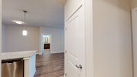 This single-floor residence presents a cohesive, contemporary design throughout. The kitchen serves as a functional centerpiece, featuring dark-toned cabinetry, granite countertops, a subway tile backsplash, and a full suite of stainless steel appliances including a range, microwave, dishwasher, and refrigerator. Pendant lighting illuminates a peninsula with an undermount sink, creating a practical workspace that opens toward the living areas.

Wood-style flooring runs consistently throughout the unit, providing a warm and unified aesthetic. The living and dining areas are generously proportioned, with ceiling fans providing comfort and windows fitted with horizontal blinds allowing for adjustable natural light.

The bedrooms are well-sized, each equipped with ceiling fans and ample natural light from window placements. At least one bedroom features direct access to a walk-in closet with built-in shelving and rod systems for organized storage.

Two bathrooms serve the unit. One includes a tub-shower combination, granite-topped vanity with dark wood cabinetry, and a large framed mirror. The second bathroom features a sliding glass-door shower enclosure, matching granite counters, and wood-style flooring. Both bathrooms are finished with consistent, modern fixtures throughout.