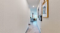 Located at 8050 Lapis Ln NW in Concord, NC, this single-floor residence offers a thoughtfully designed layout that balances comfort and modern style. An entry hallway adorned with a curated gallery wall sets an inviting tone, leading into the main living areas finished with light hardwood-style flooring throughout.

The living room is a standout space, bathed in abundant natural light streaming through large, floor-to-ceiling windows that frame outdoor views. The room is anchored by a ceiling fan and features generous space for seating arrangements, making it ideal for both relaxing and entertaining.

The kitchen is well-appointed with crisp white shaker cabinetry, granite countertops, a classic subway tile backsplash, and stainless steel appliances. A central island provides additional prep space, while a large window above the sink brings in natural light and outdoor views.

The bedrooms are comfortably sized, each featuring plush carpeting, natural light from well-positioned windows, and warm accent walls. The primary bedroom includes access to a walk-in closet, adding practical storage. The bathroom is finished with neutral tile flooring, granite vanity countertops, and a soaking tub-shower combination with full tile surround, contributing to a clean and relaxing atmosphere throughout the home.