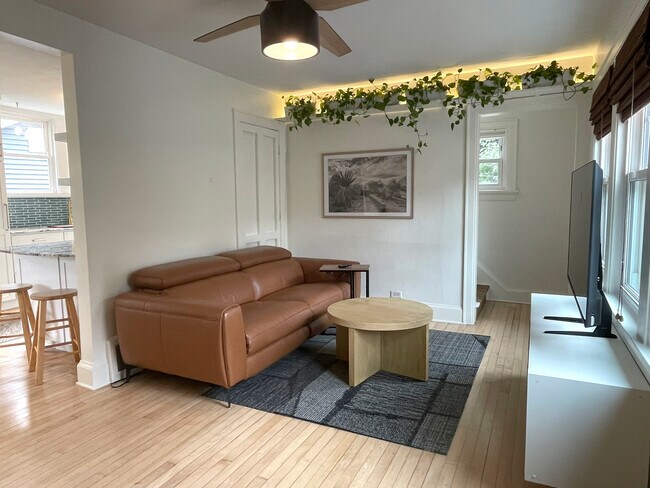 Sala de estar luminosa y acogedora con pisos de madera originales. - 3209 Atwood Ave